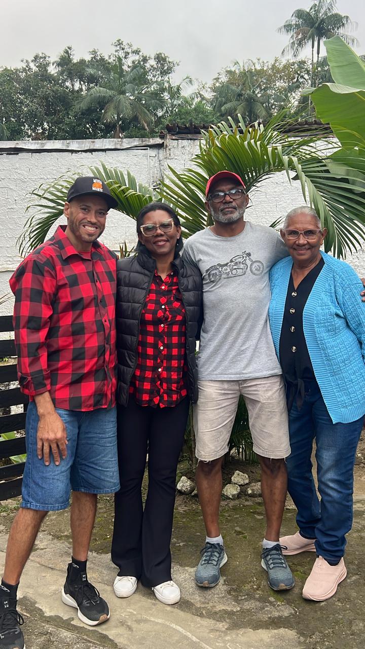 Quatro pessoas reunidas junto ao jardim.