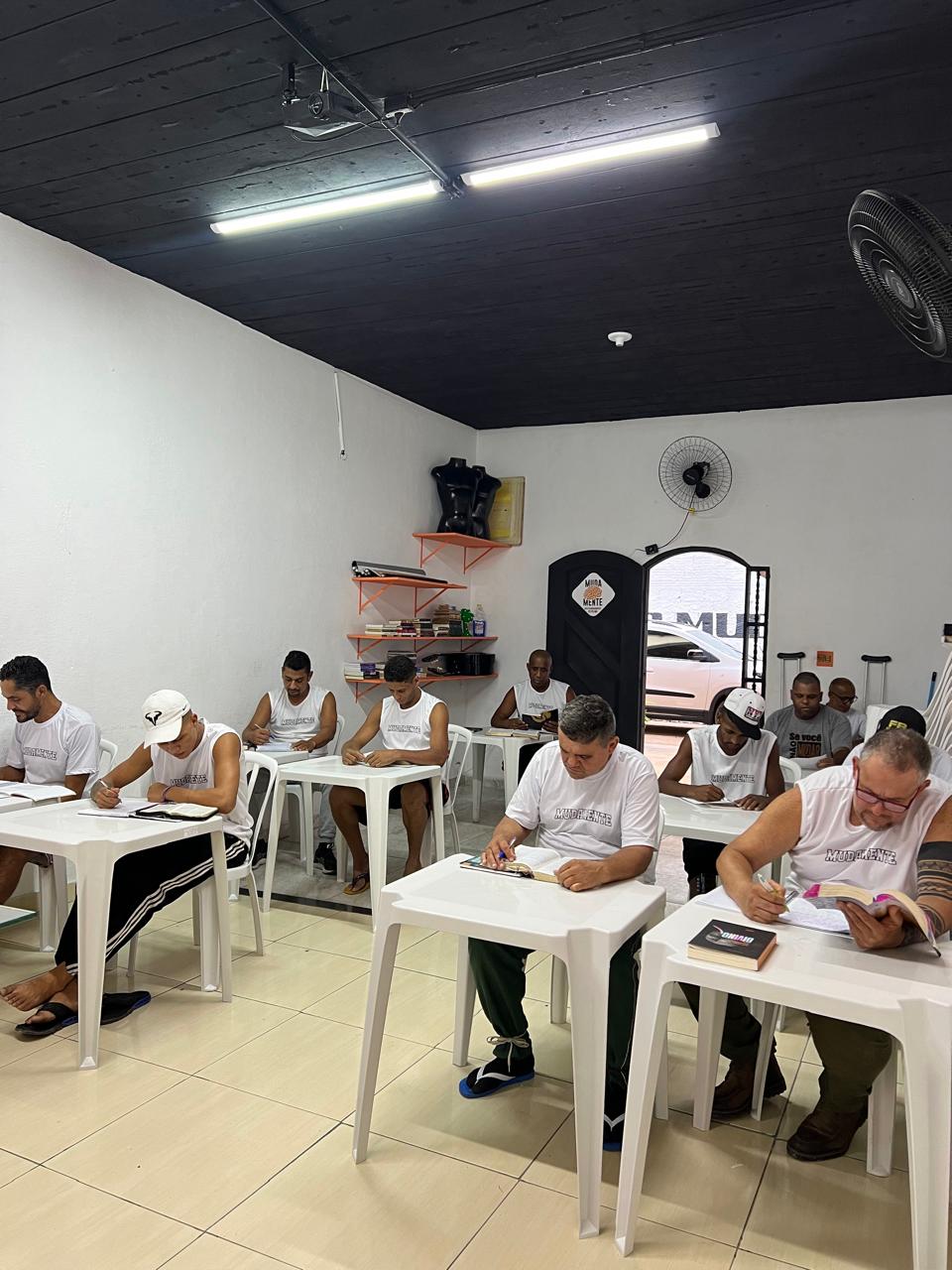 Pessoas lendo e escrevendo à mesa.